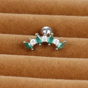 Macro view of curved cartilage earring with silver base and green marquise zircons