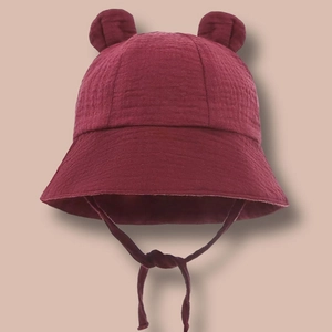 Detailed texture of dark red cotton baby bucket hat with cute 3D bunny ears and chin straps