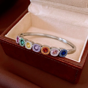 Detail of silver vintage branch texture cuff with seven colorful round gemstones and diamonds