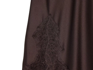 Detail of dark brown silky satin fabric with intricate matching lace trim and glossy texture