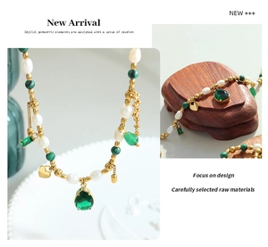 Detail of vintage necklace with freshwater pearls, green malachite, and gold heart charms