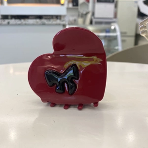Elegant red heart-shaped acetate hair claw clip with a 3D black bow accent for women