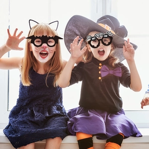 Kids wearing black bat and spider-themed paper glasses for Halloween party decoration