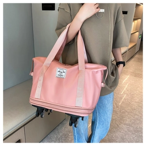 Pink expandable travel bag with swivel wheels showing handle grip and extension layer