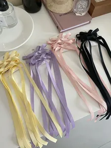 Detailansicht der langen Satin-Haarspangen mit Schleifen in Gelb, Lila, Rosa und Schwarz