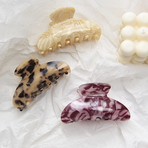 Three classic large acetate hair claws in leopard, amber and marble patterns