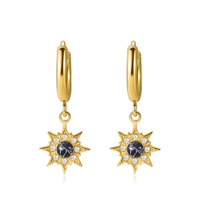 Detail view of gold starburst earrings with black marble stone and sparkling zircons