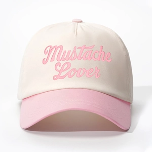 Close-up of pink 'Mustache Lover' embroidery on a cream and pink baseball cap detail