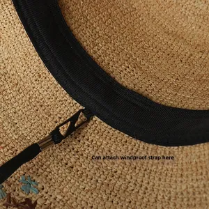 Detail of raffia sun hat interior showing sweatband and hook for windproof rope attachment
