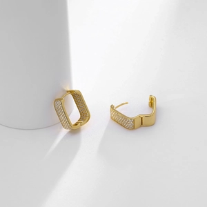 Macro shot of gold square hoop earrings with sparkling cubic zirconia pavé stones