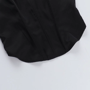 Vue macro détaillée de l'ourlet incurvé et des coutures sur le haut corset en satin noir