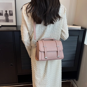 Modern pink PU leather crossbody bag worn by a model in a minimalist indoor setting