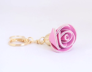 Gros plan d'un porte-clés rose en cuir avec des détails métalliques dorés brillants
