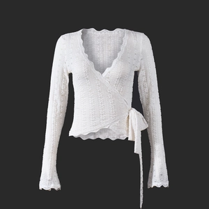 Detail eines weißen Spitzentops mit seitlicher Schnürung und feinem Lochstrickmuster