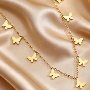 Detailed macro view of gold-plated butterfly charms on a premium O-chain necklace