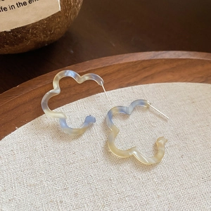 Detail view of flower-shaped resin hoop earrings with a colorful gradient finish