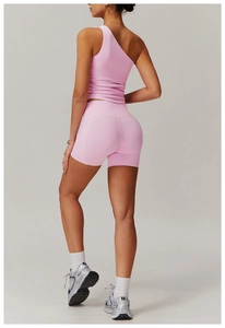 Détail du haut rose à une épaule et du short de sport taille haute pour femme