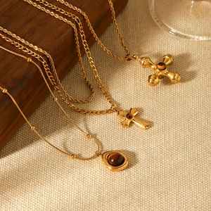 Three gold stainless steel layered necklaces with tiger eye stone and cross pendants