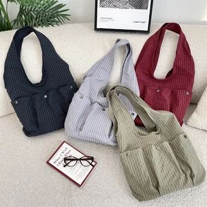 Detailed view of canvas tote bags with checkered patterns and functional front pockets