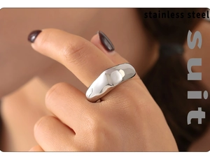 Gros plan d'une bague large en acier inoxydable argenté poli avec finition miroir brillant
