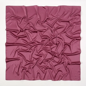 Close-up detail of soft matte satin silk square scarf in deep rose color with elegant drapes