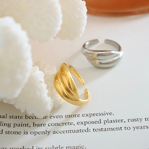 French style 18K gold and silver plated twisted open rings on a book page