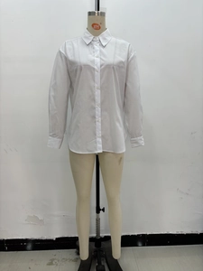 Close-up detail of white cotton shirt featuring a classic collar and button-down front