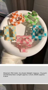 Top view of colorful matte checkerboard hair claws arranged in a white ceramic dish