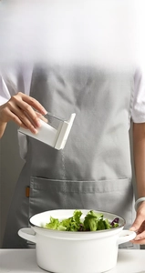 Close-up of food-grade clear seasoning shaker pouring salt in a modern kitchen setting