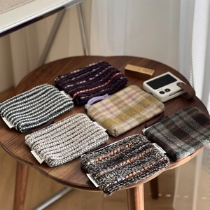 Close-up of vintage plaid and striped mini fabric pouches on a wooden table surface