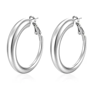 Close-up of polished silver stainless steel chunky hoop earrings with mirror finish