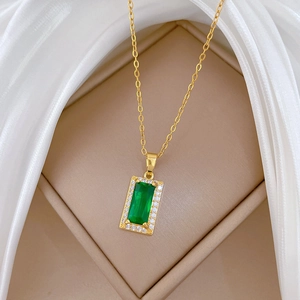 Luxurious gold necklace featuring a green rectangular stone pendant in a jewelry box