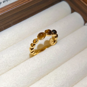 Gros plan sur la bague en œil de tigre plaqué or avec design festonné vintage en boîte