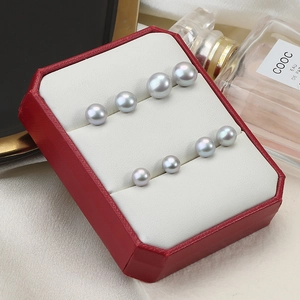 Elegant grey freshwater pearl stud earrings in four sizes displayed on a red jewelry box