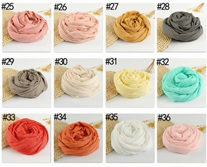 Collection of linen scarves in twelve vibrant colors with fringe edges in spiral fold