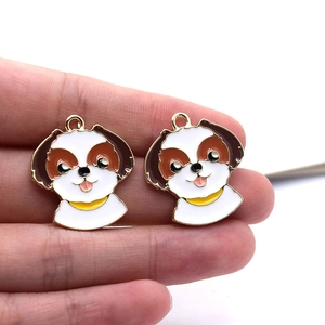 Macro shot of two cute cartoon dog charms with enamel finish and gold edges