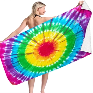 Detailed texture of vibrant rainbow tie-dye microfiber beach towel held by a model