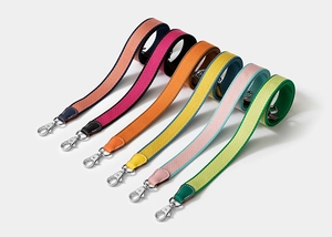 Detail showing various colorful canvas bag straps with leather ends and metal buckles