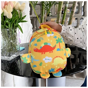 Detail of yellow dinosaur kids backpack with cartoon prints and side fin decorations