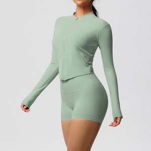 Detail view of mint green high-waisted yoga shorts and long sleeve zipper top fabric texture