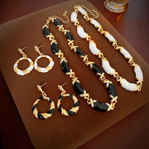Vintage geometric jewelry set with gold necklaces and enamel earrings in black and white