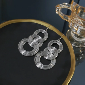 Silver multi-layer concentric circle earrings displayed on a premium jewelry tray