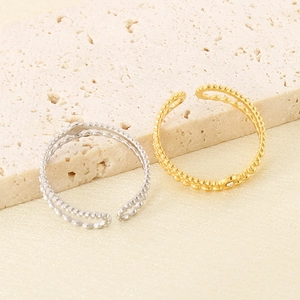 Detailed macro view of French vintage gold and silver layered beaded open rings on stone