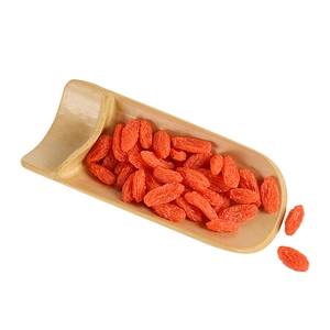 High-quality dried goji berries with full texture shown in a bamboo spoon on white background