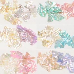 Macro shot of colorful irregular natural shell fragments for nail art in six color options