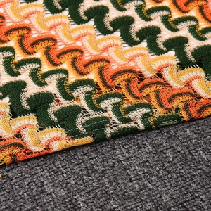 Détail macro de la robe moulante montrant la texture du crochet zigzag coloré