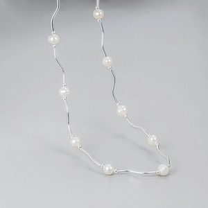 Collana minimalista a onde argentate con perle d'acqua dolce naturali dal design curvo