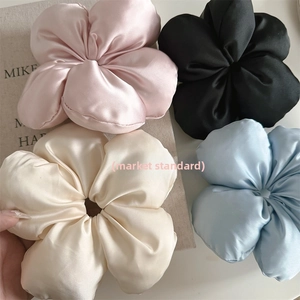 Close-up of four-piece set silk flower hair scrunchies in pink, black, cream, and blue