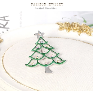 Detail of Christmas tree brooch with green enamel and sparkling colorful rhinestones