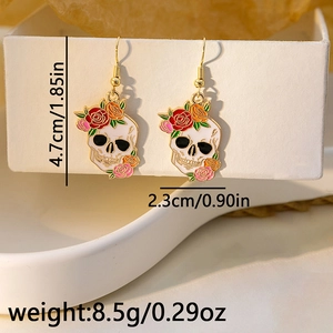 Close-up of skeleton and rose hook earrings featuring white enamel and gold hooks